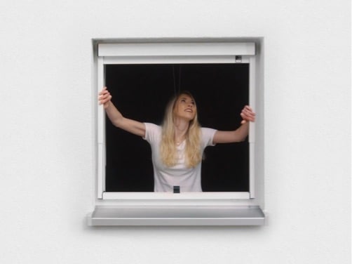 La clienta instala su estor enrollable exterior en la ventana sin taladrar